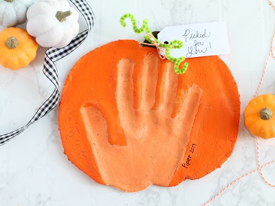 Handprint pressed into a clay pumpkin