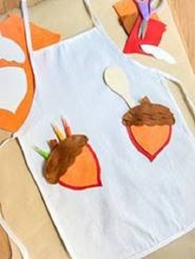 Apron with two pockets that are painted to look like acorns